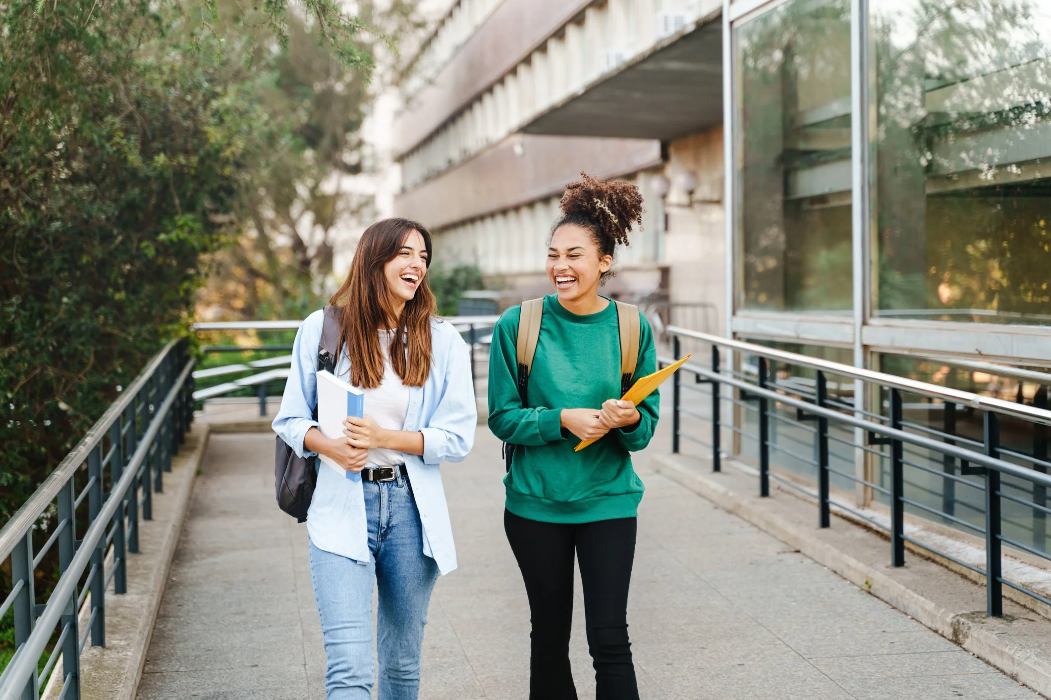 Two high school seniors walking on campus, confidently navigating college applications with the help of a college coach