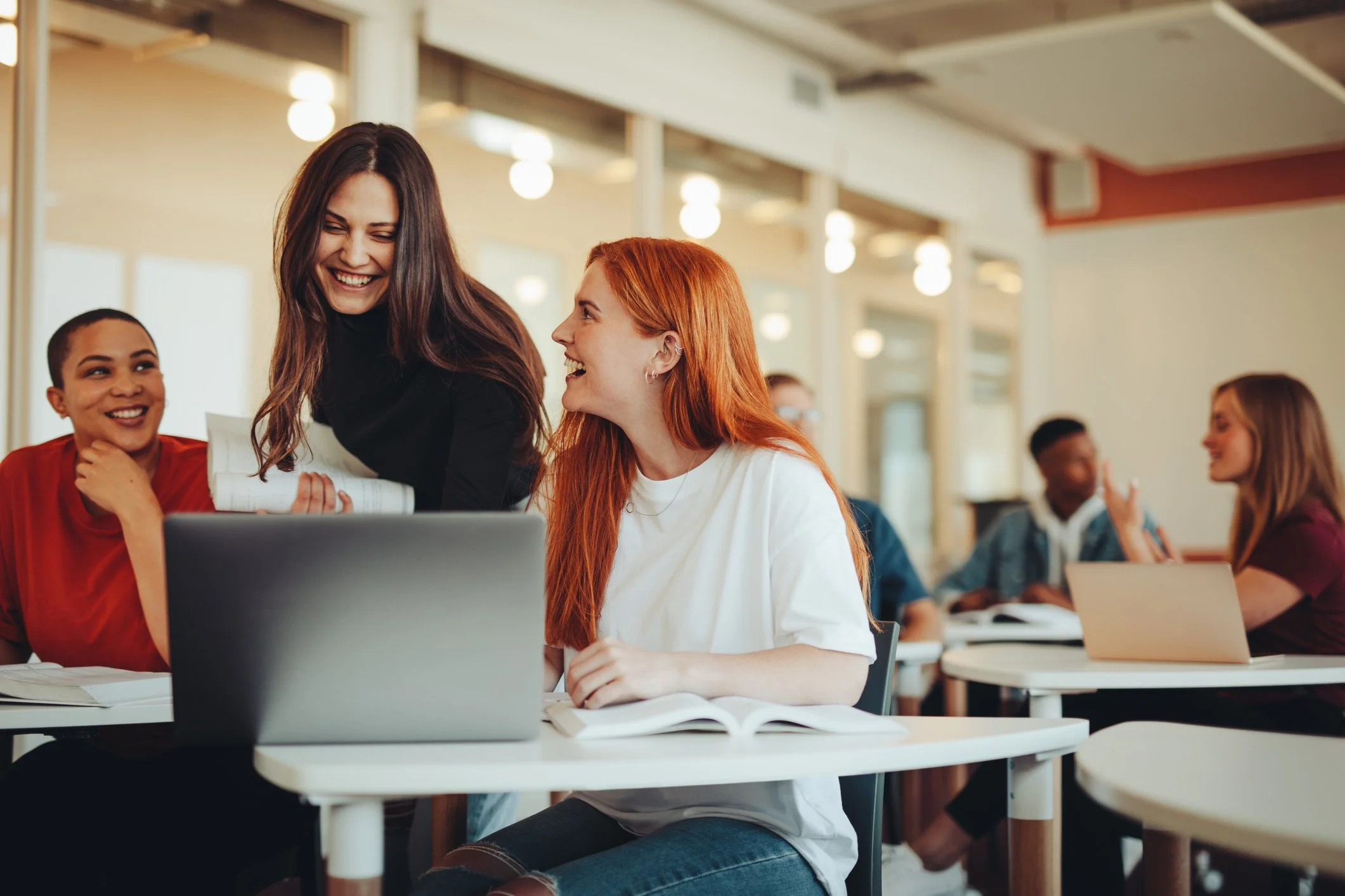 Group of diverse young adults in classroom or study group with laptops